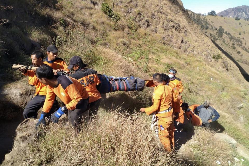  Rescuers carrying out the body of an Indonesian hiker as the death toll rises to 16