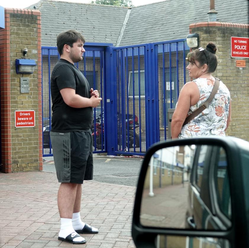  Holmes looks nervous as he stands by his mum Cathy, who marched him down to the police station