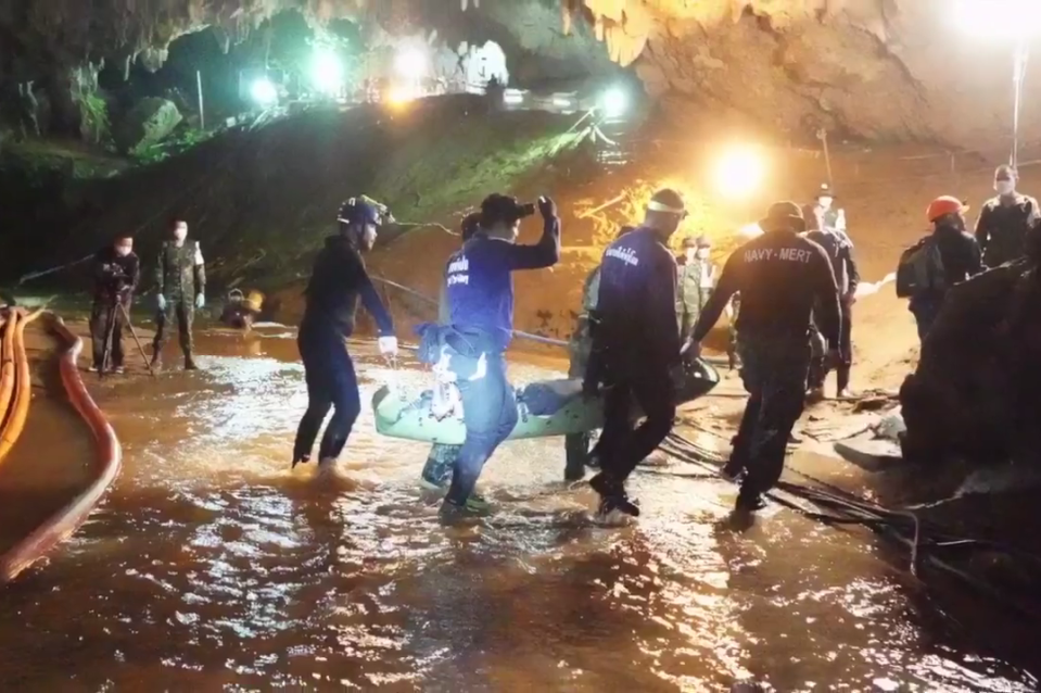  Rescuers are seen stretchering one of the trapped boys from the cave