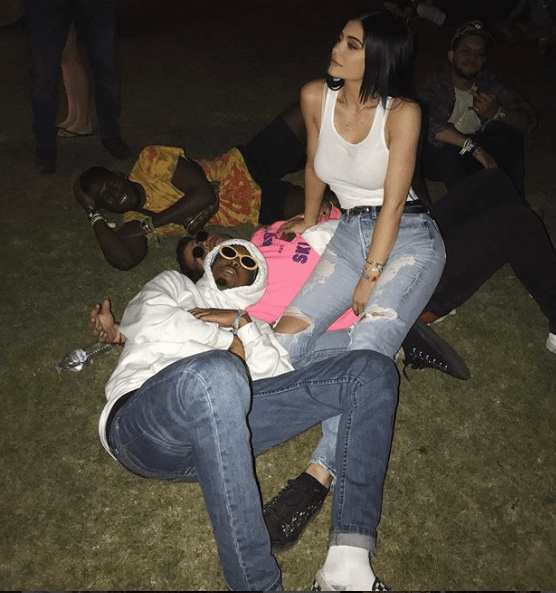  Kylie shared a picture of herself and Travis with friends lying in the grass at Coachella