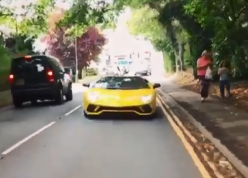  Henry driving a Lamborghini in a scene from Absolutely Ascot