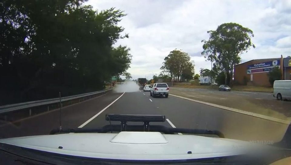  A large cloud of smoke appears behind the white saloon car