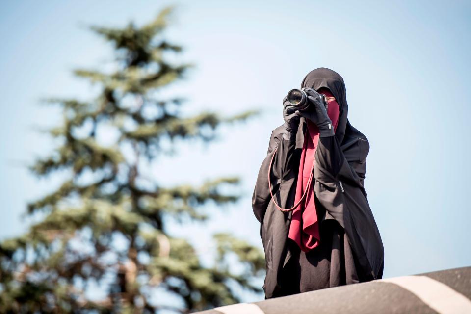  A veiled woman captures the emotions of the day on her own camera