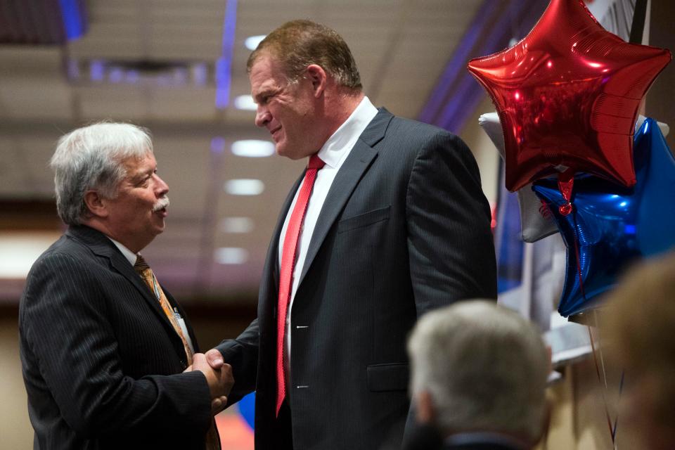 GOP chair Buddy Burkhardt, left, shakes the hand of Glenn Jacobs after early results showed the wrestling icon was winning the mayoral race