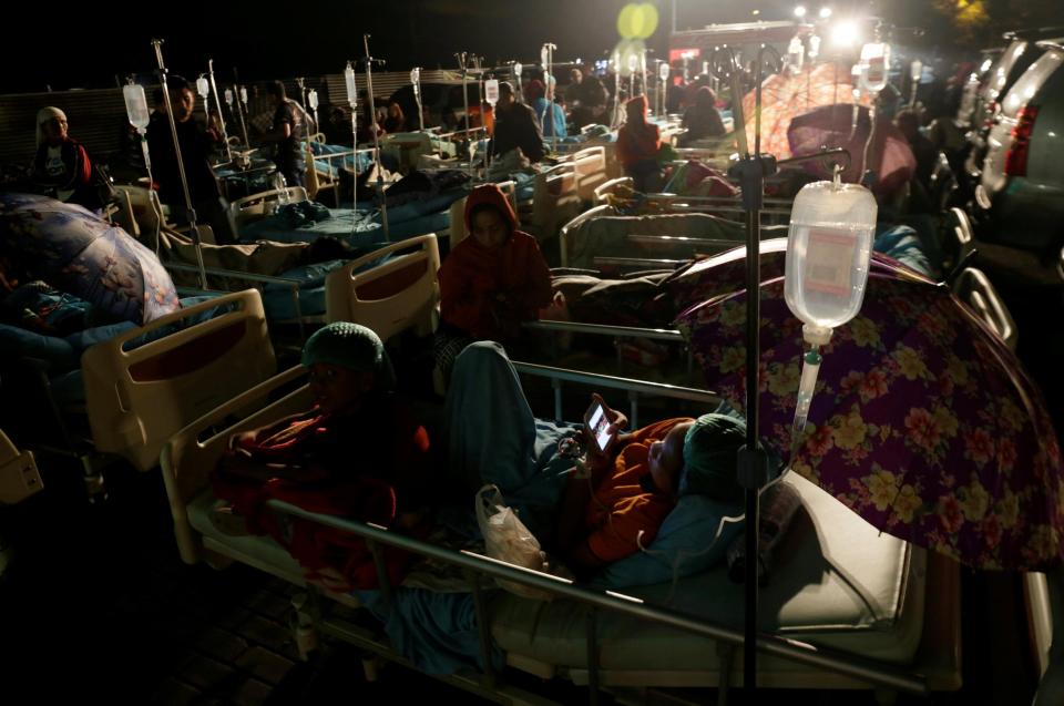  Hospital patients and relatives wait outside after being evacuated after an earthquake rocked Indonesia's Lombok island