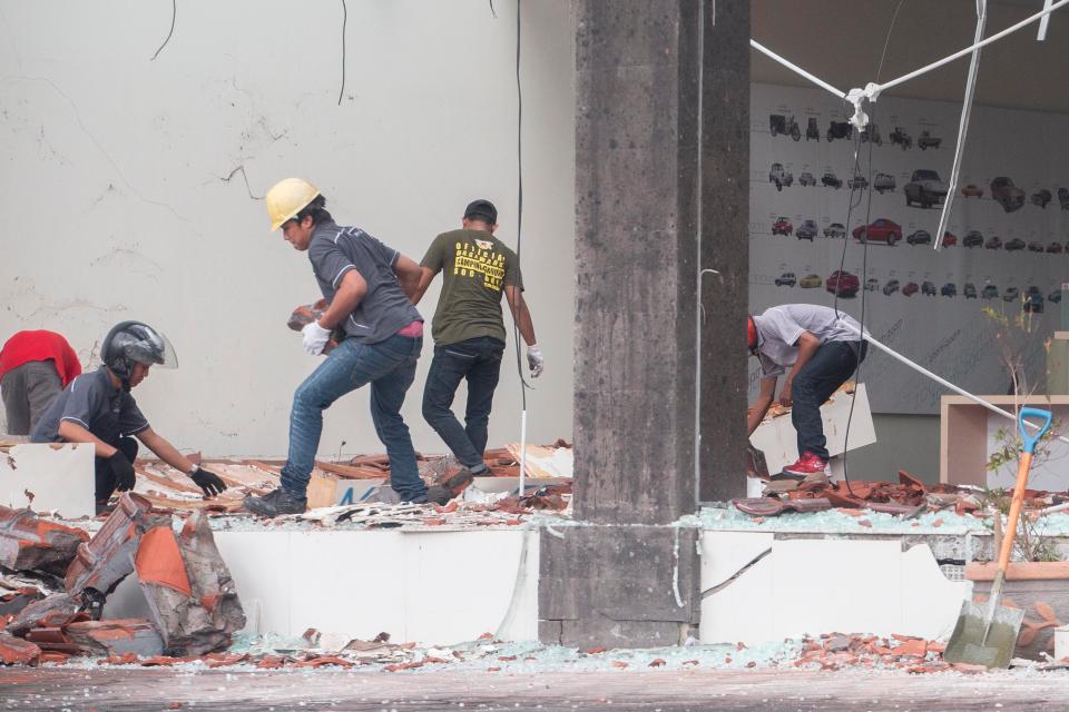  Workers clean up parts of a building which collapsed after an earthquake, in Denpasar, Bali