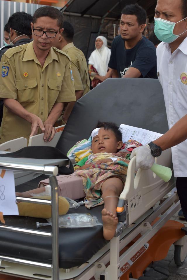  An injured boy receives medical help at a makeshift ward set up in Lombok