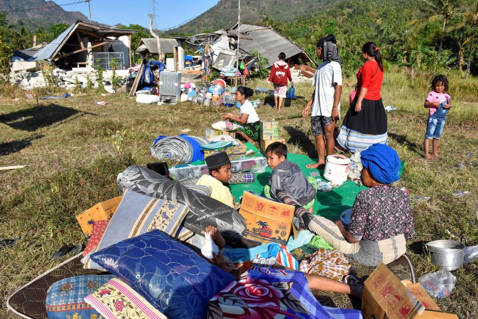  Residents sit outside their home with their belongings following the earthquake which triggered a tsunami warning