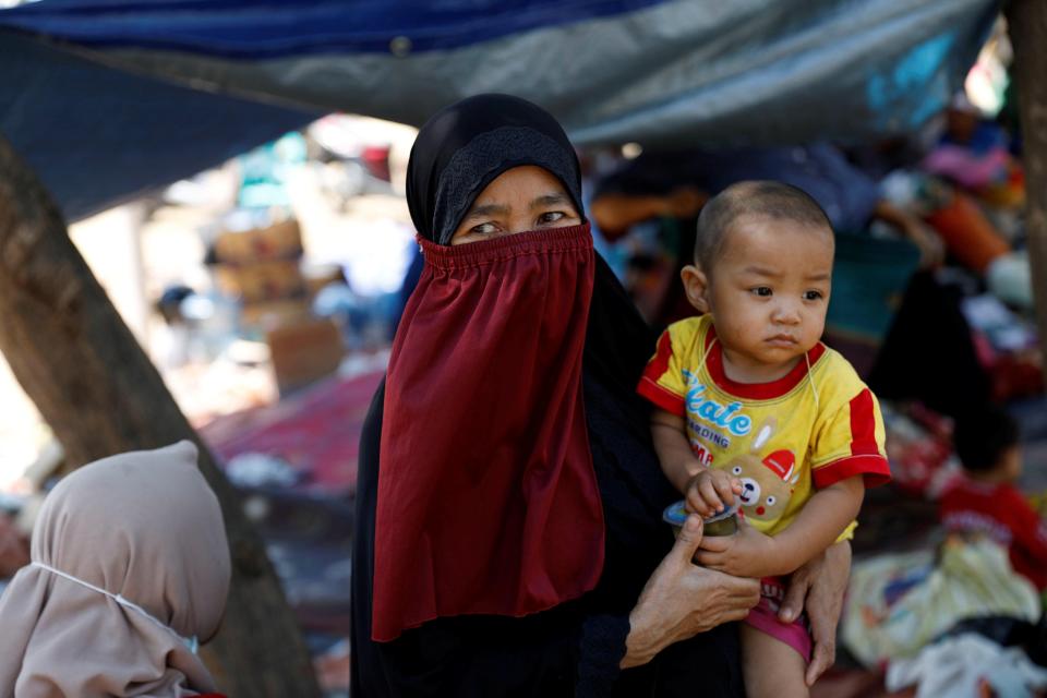  A villager holds her child in a temporary shelter after the devastation visited upon the Indonesian island