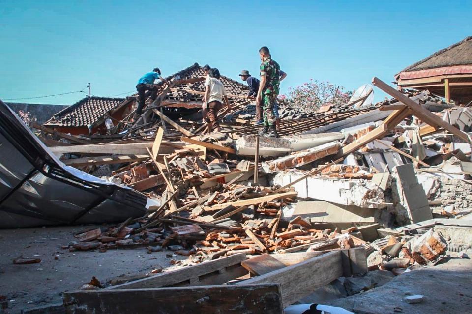  Indonesian rescuers search for victims under the ruin of a collapsed house in North Lombok