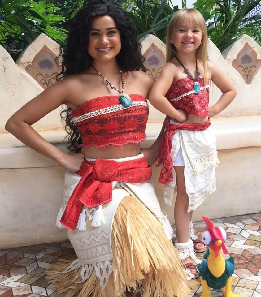 Riley poses with a Disney cast member dressed as Moana at the park