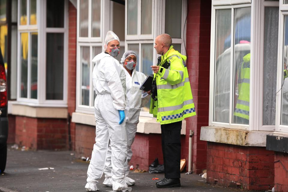  Forensic officers consult a cop at the scene