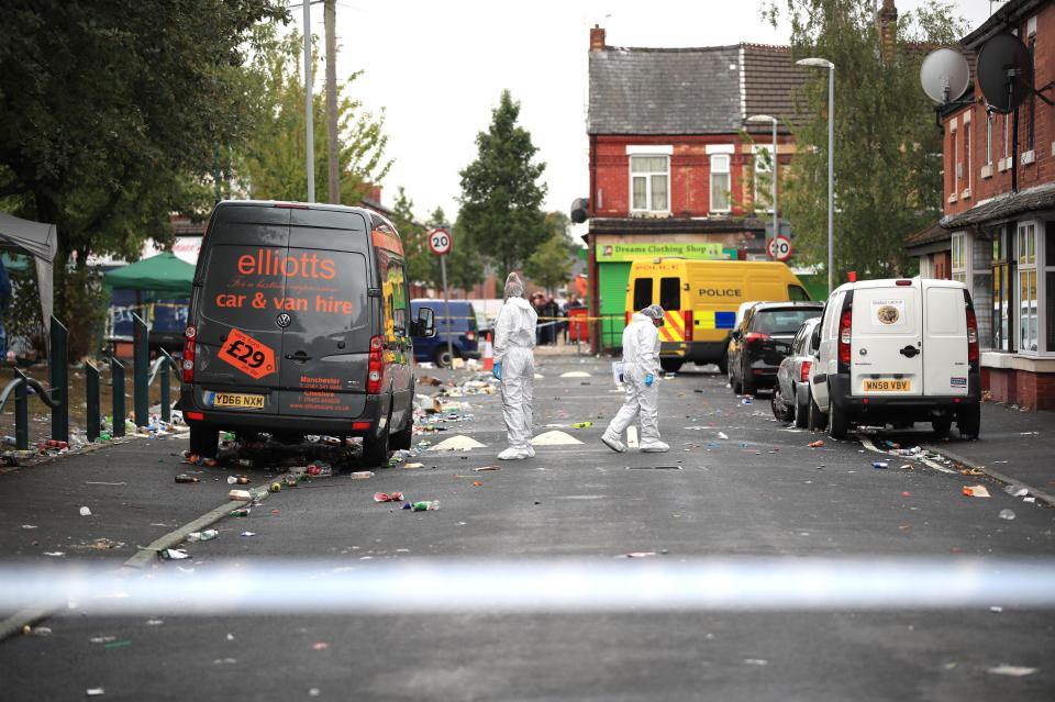  Two forensic officers at the scene of the shooting in Moss Side, Manchester