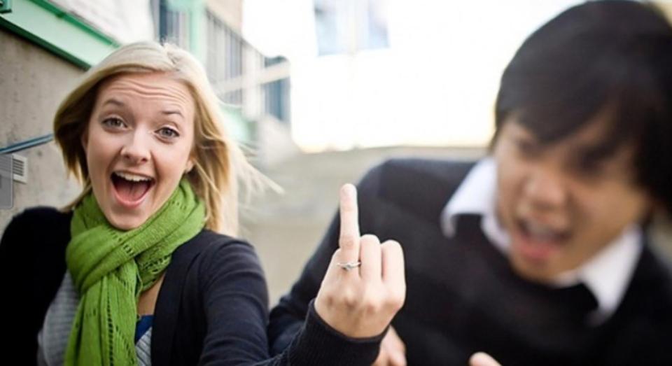  An excited bride shows off her new engagement ring by flipping her finger to the camera