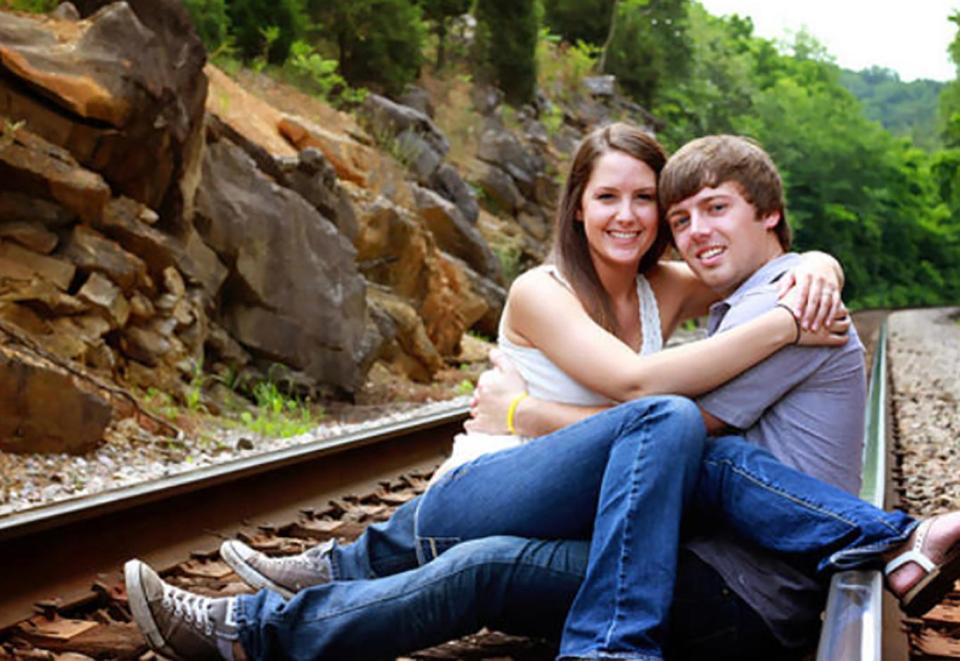  A daredevil pair sprawl across a railway track to announce their happy news