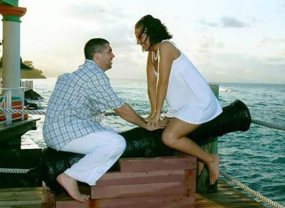  This couple balance on a canon by the coast in their engagement shot