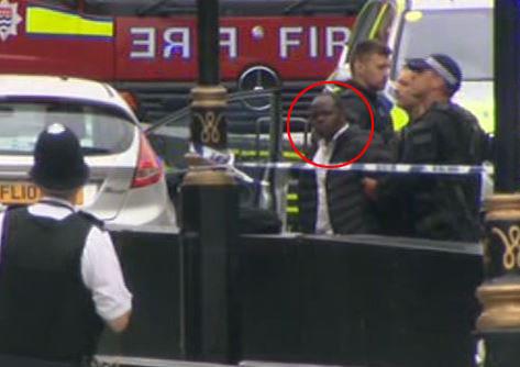  The driver of the silver car is led away from the scene by cops outside Parliament this morning