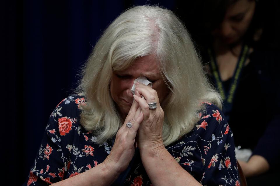  Judy Deaven, who says her son was a victim of sexual abuse by a priest as a boy, wipes her eyes during the news conference