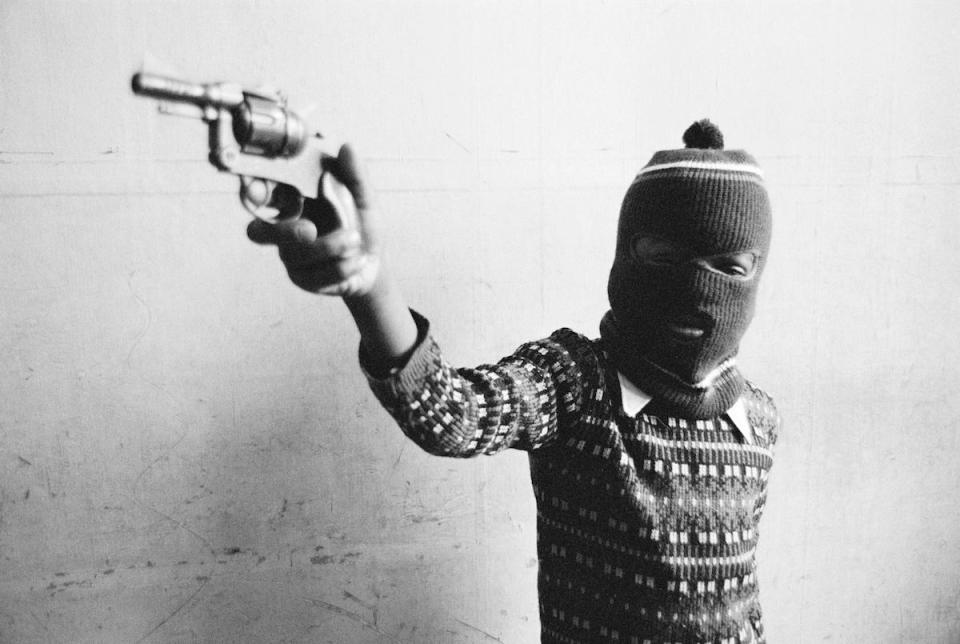  A balaclava-clad boy wields a weapon in Young Gun, taken in 1969. The photo was taken by the Jamaica-born photographer Dennis Morris when he was just nine years old