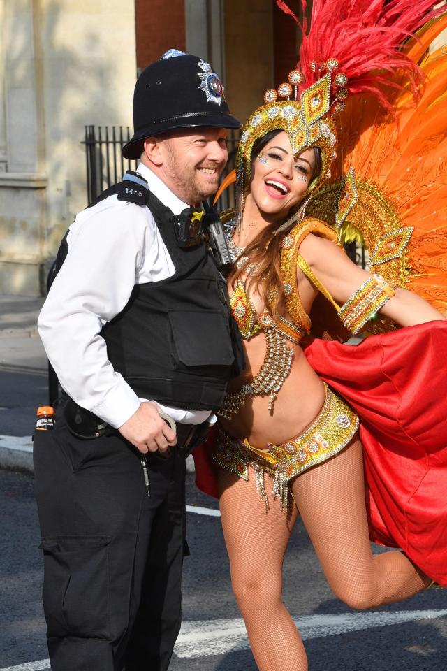  A grinning police officer poses with a dancer