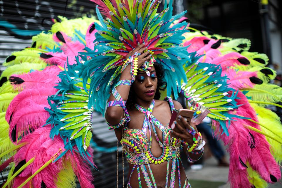  A brightly-coloured carnival queen checks her phone