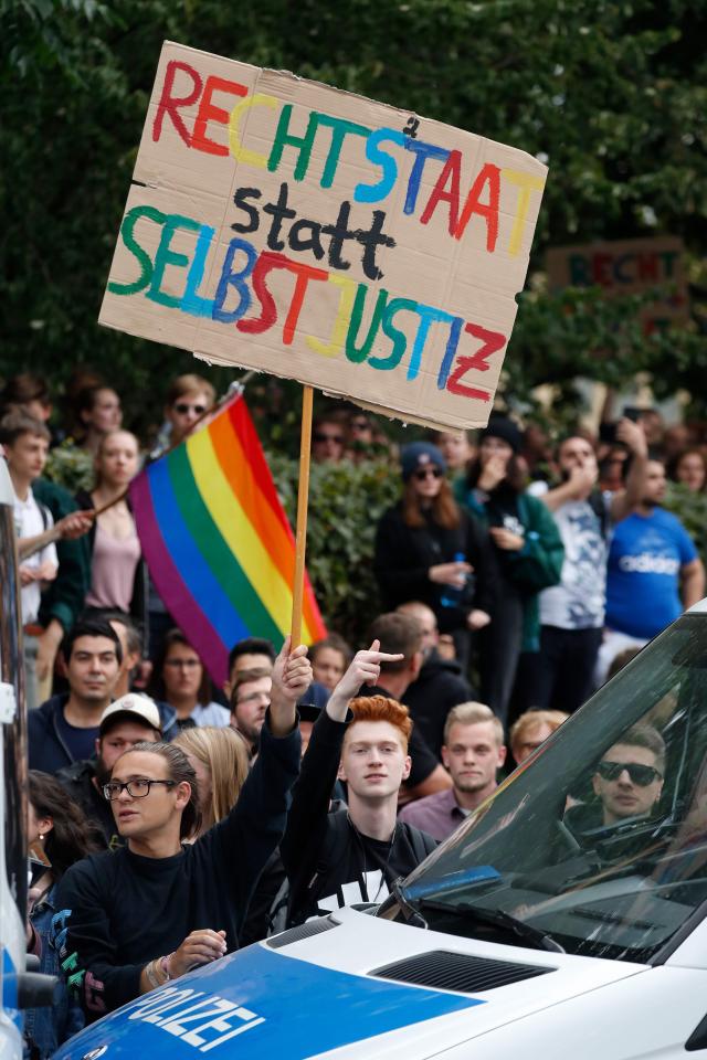  Counter protesters hold up a placard which reads 'rule of law not vigilante justice'