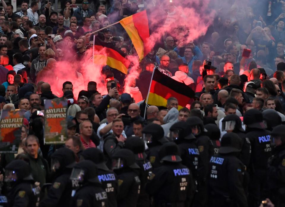  In chaotic scenes on the streets of Chemnitz, demonstrators lit flares and clashed with cops