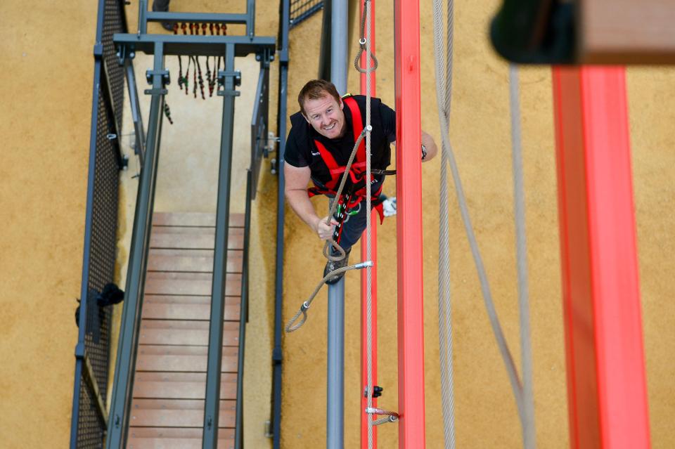  Bear Grylls' pal, Scott, looks up as he attempts to climb Europe's largest free-roam ropes course