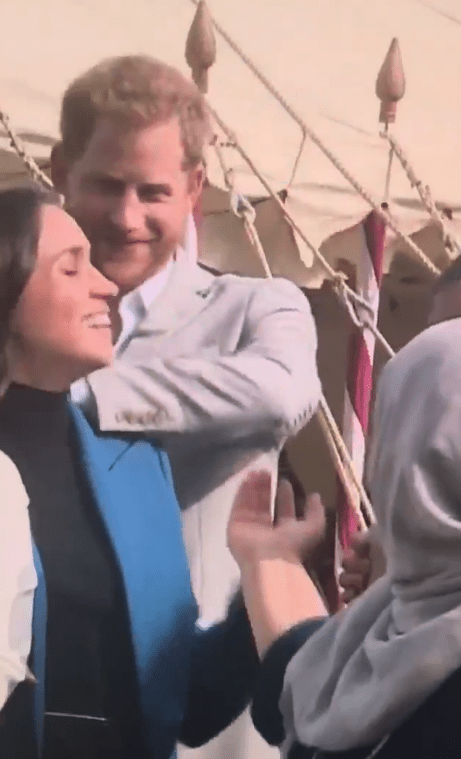  Meghan beamed as her husband gently pulled her locks out of her face