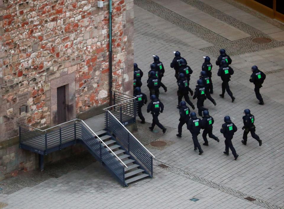  Police officers run after left-wing protesters who tried to stop the march