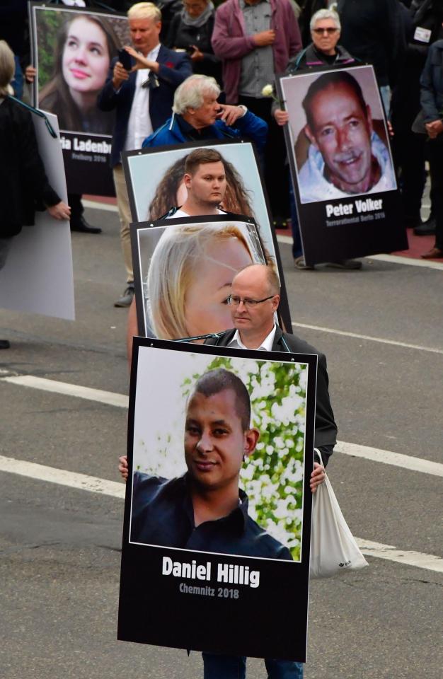  Demonstrators hold up placards showing portraits of alleged victims of refugees criminals