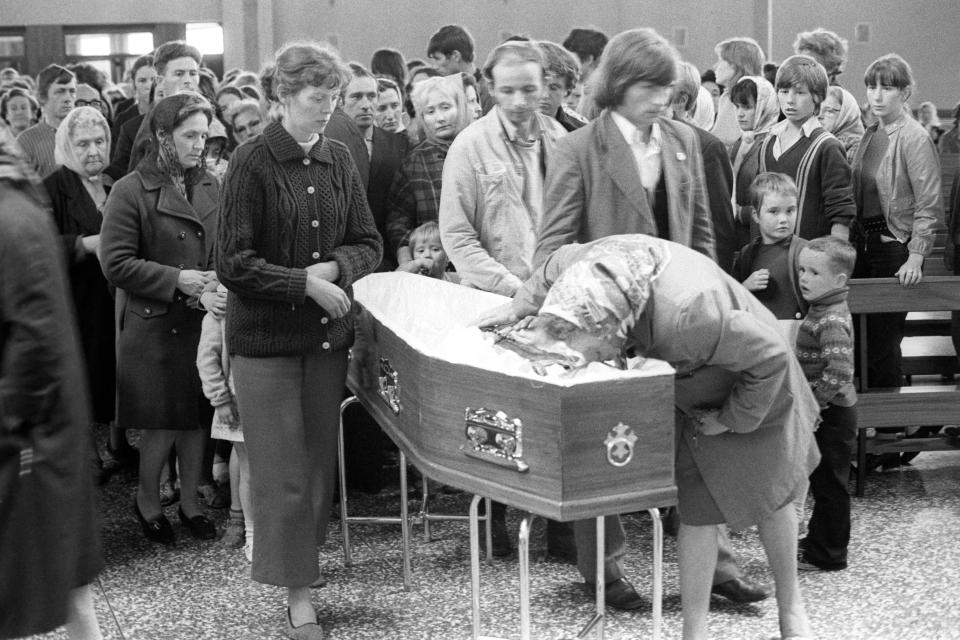  Mourners file past the coffin of Father Hugh Mullan, the first victim of the Ballymurphy Massacre by British troops in 1971