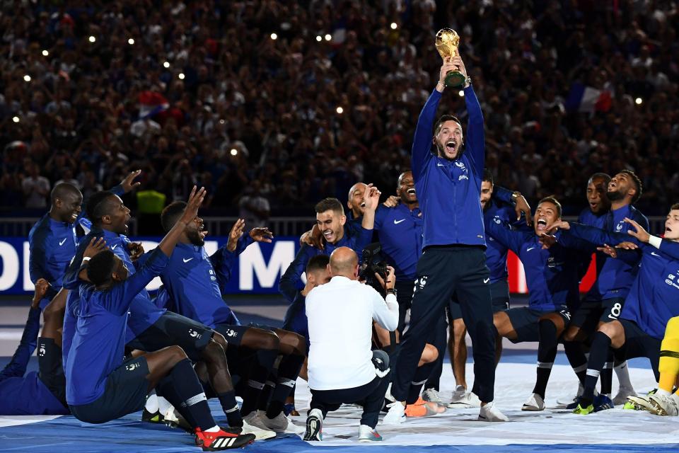 Hugo Lloris lifts the World Cup trophy as his France team-mates fall to the floor