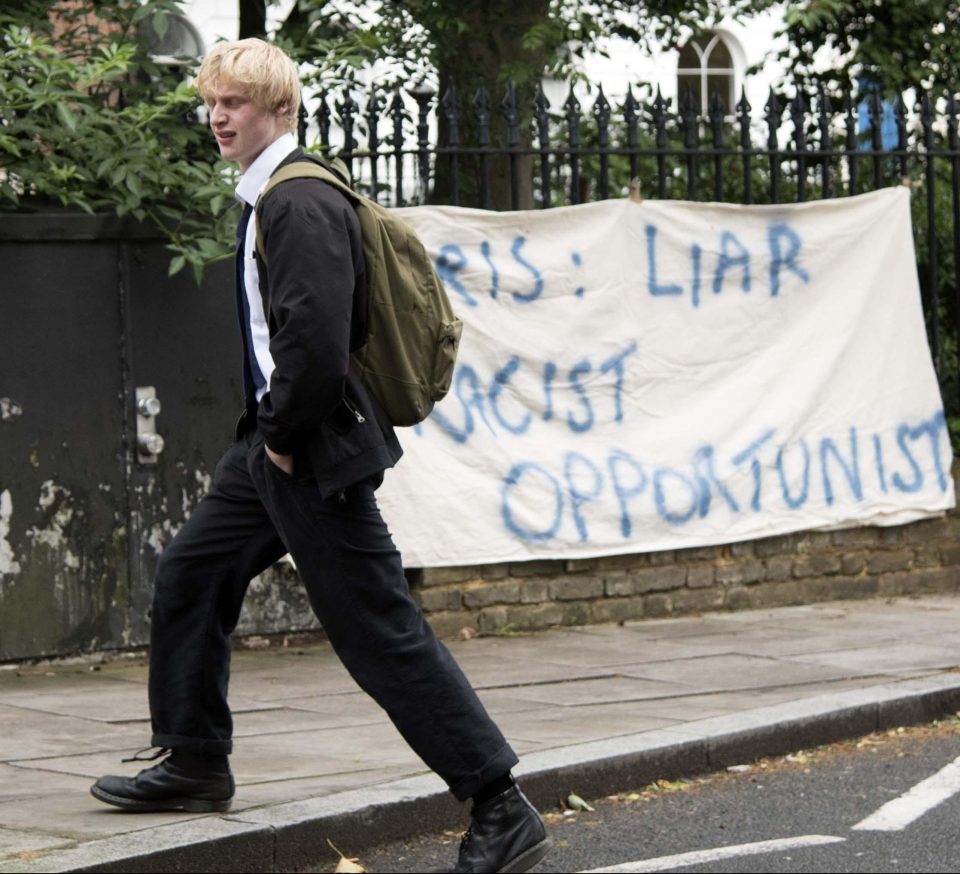  Theodore was pictured in school uniform walking past a protest by his home