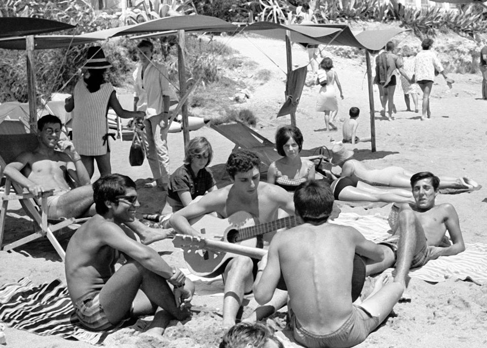  Malaga back in the 1960s, as tourists sunbathe on the beach with their guitars