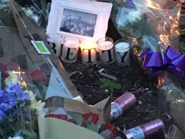  Candles that spell Betty's name and roses have been left at a memorial