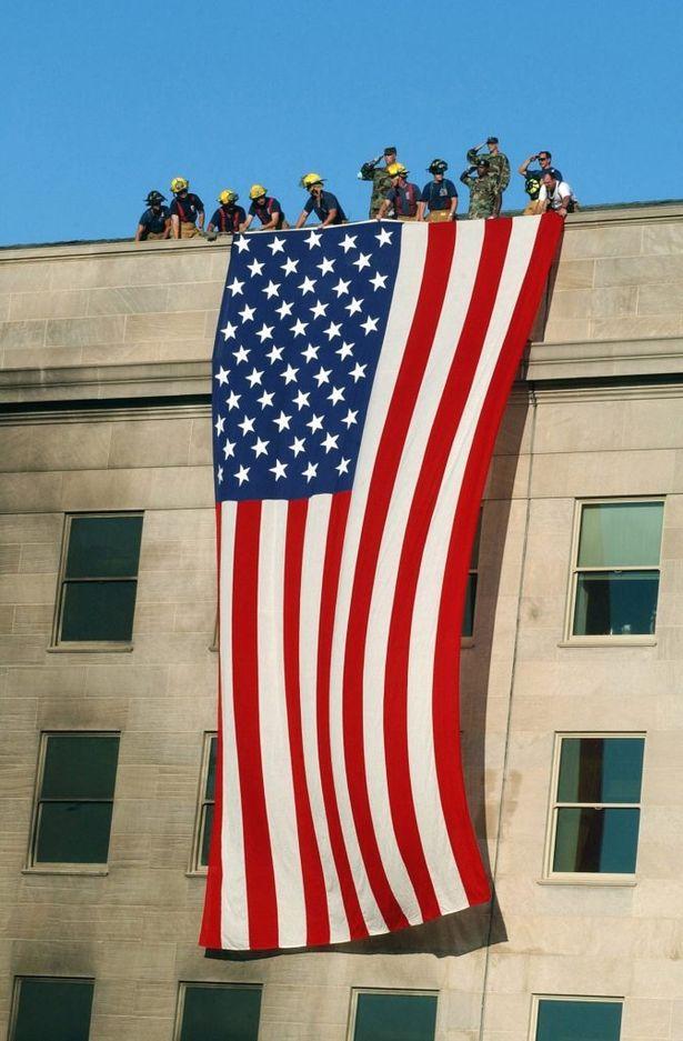  Firefighters and soldiers drape a Stars and Stripes over the Pentagon