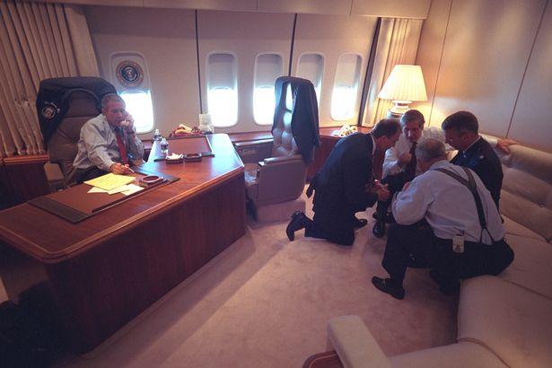  George W Bush talks on the phone on Air Force One while his aides discuss events