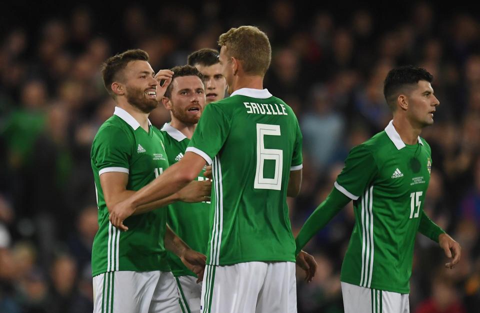  Dallas reacts with his team-mates after grabbing his third international goal