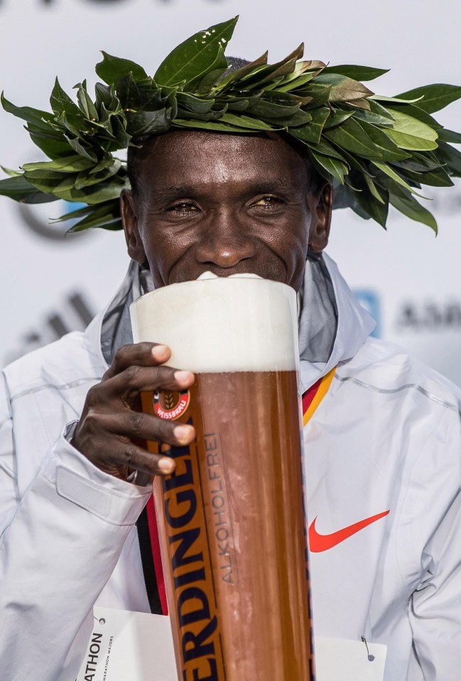 Kipchoge celebrates by tucking into a massive stein of beer in Berlin after winning the Marathon