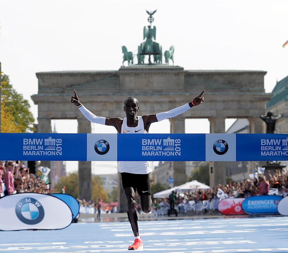 Kipchoge spreads his arms in celebration at the finish line outside the Brandenburg Gate in Berlin