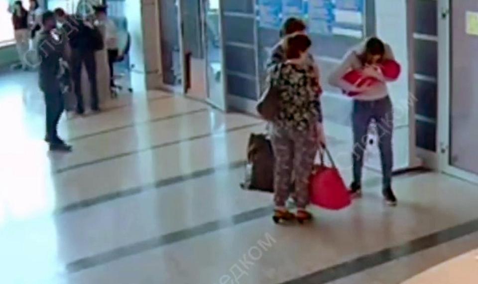  Inna Petrova kisses her baby goodbye before handing her over at Omsk airport