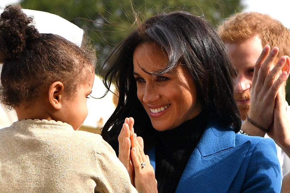  Meghan is delighted to meet a small child