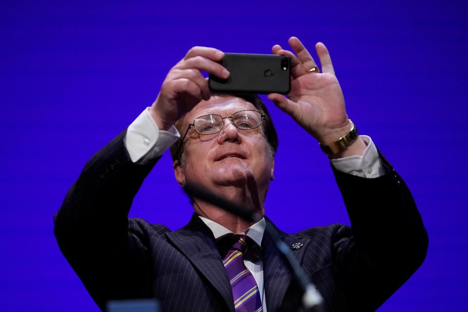 Batten photographs the audience after speaking at the annual conference