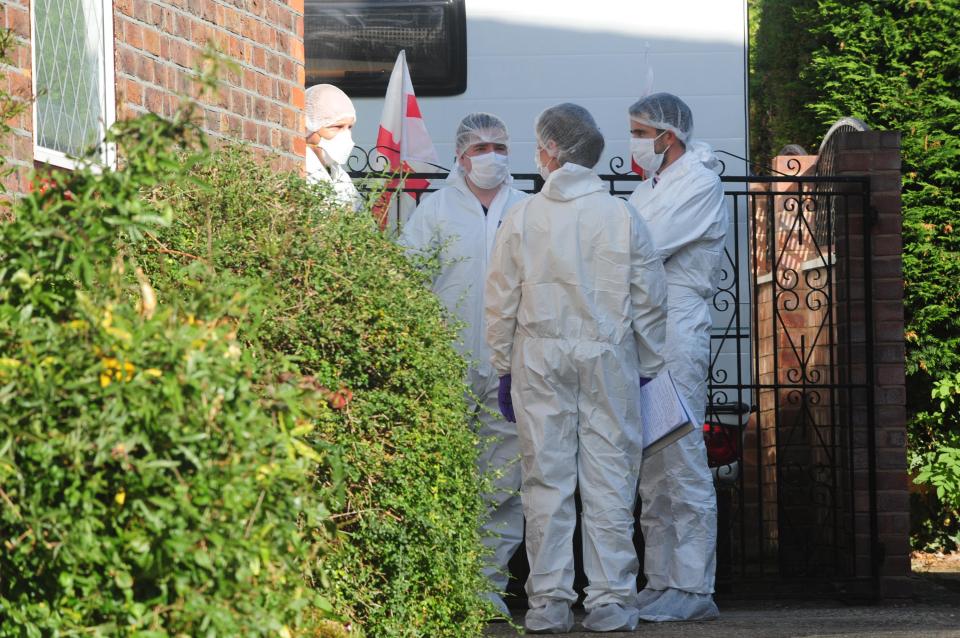  A group of forensics officers huddle outside the home in Hadlow