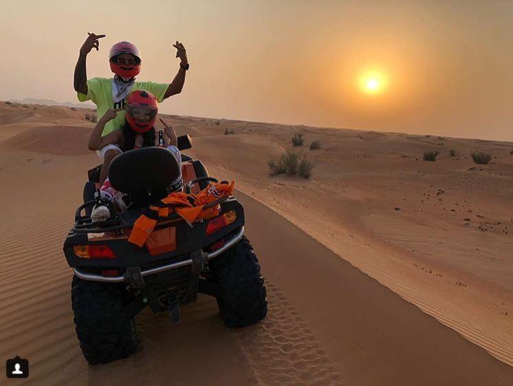  The pair flip the bird as they pose on the sand dunes in front of sunsets