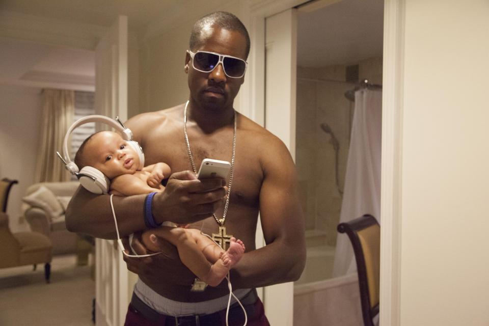  Kanye chills with mini-me Saint who sports massive headphones