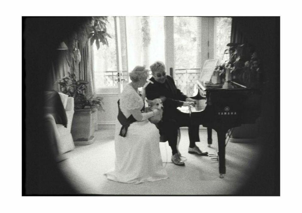  Her Majesty and her corgi are serenaded by an ever-attentive Sir Elton John