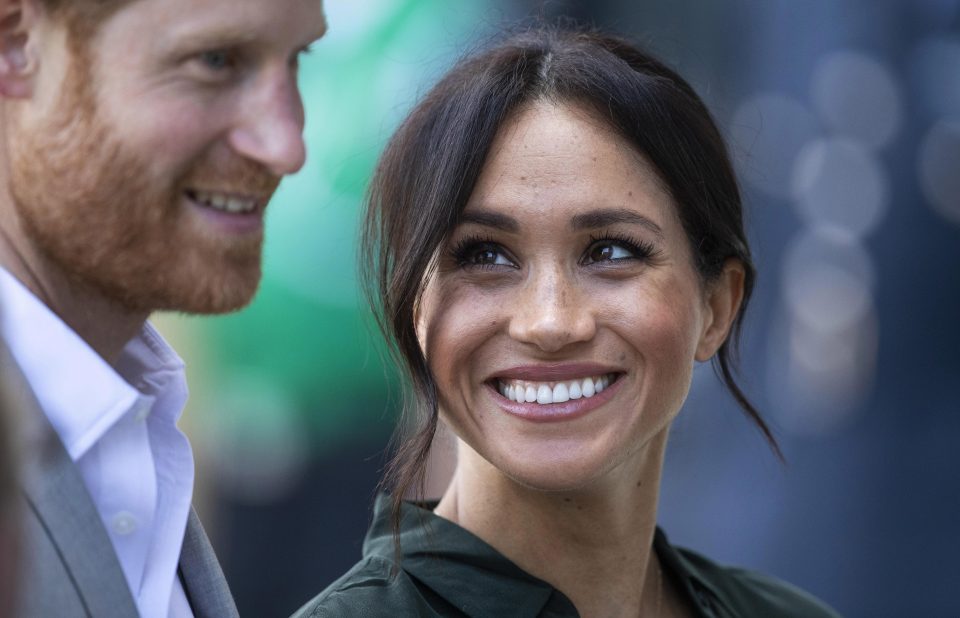  Meghan was caught smiling widely as she gazed at her husband