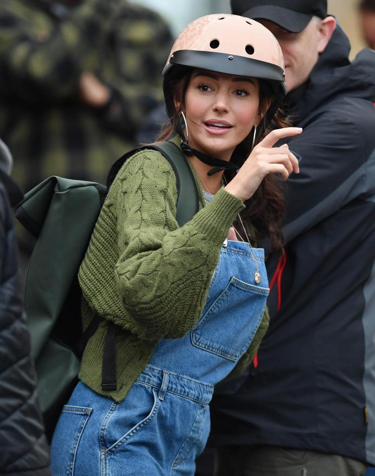  She was dressed down in dungarees, a cardi and pink helmet